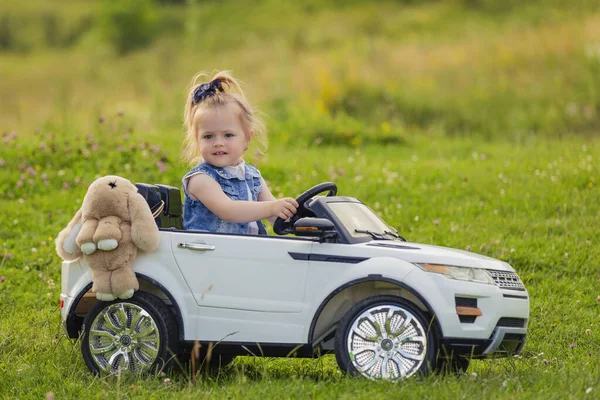 Kleines Mädchen fährt im Kinderauto — Stockfoto