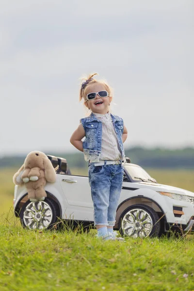 Meisje in zonnebril staat voor een auto — Stockfoto