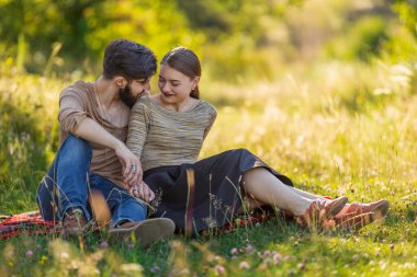 Genç çift doğada oturuyor.