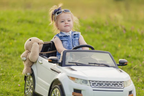 Kleines Mädchen fährt im Kinderauto — Stockfoto