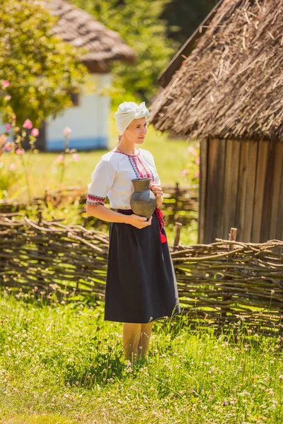 Mulher em traje nacional ucraniano com um jarro em suas mãos — Fotografia de Stock