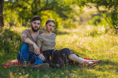 Genç çift doğada oturuyor.
