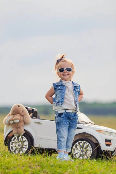 Meisje in zonnebril staat voor een auto — Stockfoto