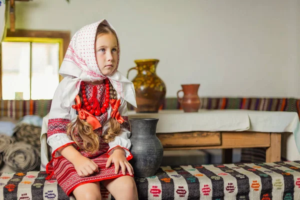 Mädchen in ukrainischer Tracht sitzt auf einer Bank — Stockfoto