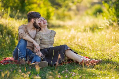 Genç çift doğada oturuyor.