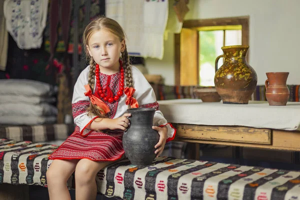 Ukrayna ulusal kostümlü bir kız bankta oturuyor. — Stok fotoğraf