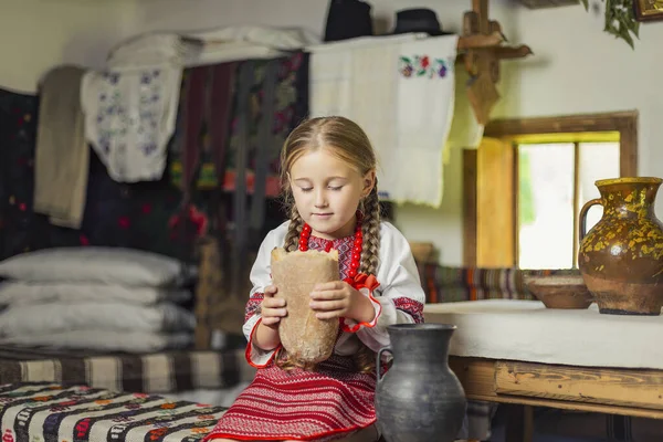 Meisje in Oekraïense nationale kostuum eet brood — Stockfoto