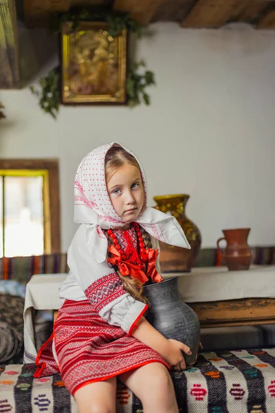 Ukrayna ulusal kostümlü bir kız bankta oturuyor. — Stok fotoğraf