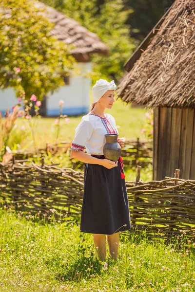 穿着乌克兰民族服装手里拿着壶的女人 — 图库照片