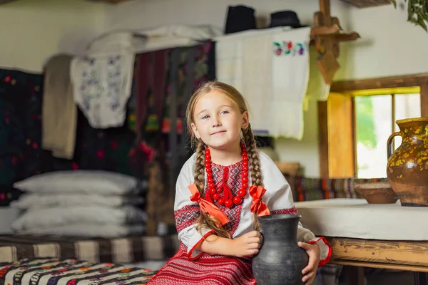 Ukrayna ulusal kostümlü bir kız bankta oturuyor. — Stok fotoğraf