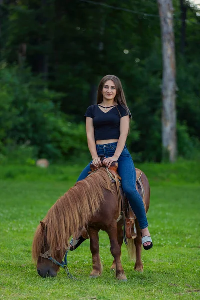 Chica montando un pony —  Fotos de Stock