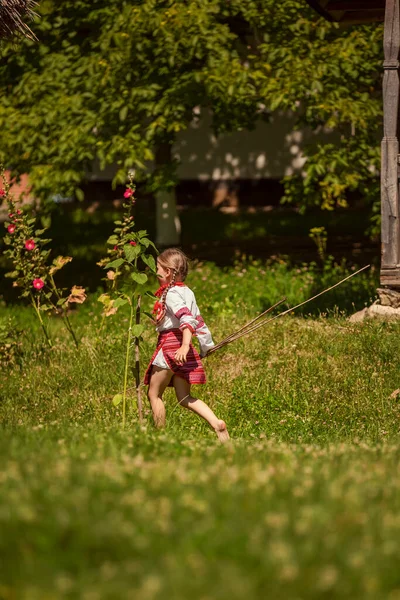 Mädchen in traditioneller ukrainischer Tracht spielt im Hof — Stockfoto