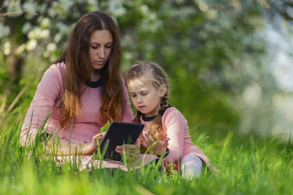 Mamá y su hija mirando una tableta —  Fotos de Stock