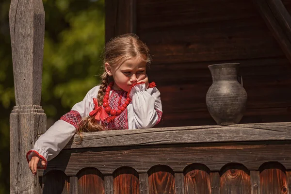 Chica en un vestido ucraniano se encuentra cerca de una jarra —  Fotos de Stock