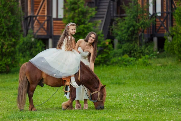 Mutter reitet ihre Tochter auf einem Pony — Stockfoto