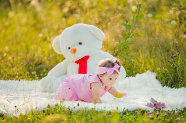 Çocuk büyük bir ayının yanında oturuyor.