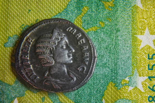 Старая римская монета лежит на банкноте евро — стоковое фото