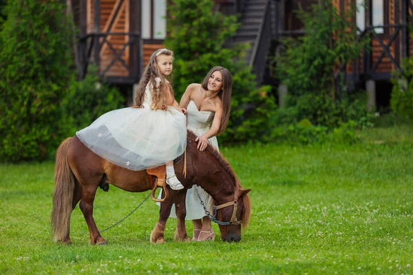 Mor rider sin dotter på en ponny — Stockfoto