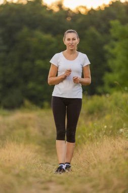 Toprak yolda koşan bir kadın