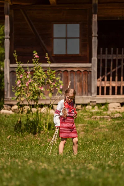 Geleneksel Ukrayna kostümlü kız bahçede oynuyor. — Stok fotoğraf