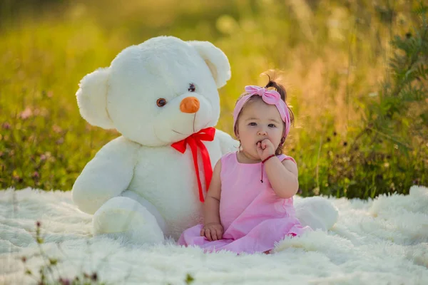Criança sentado ao lado de um grande ursinho de pelúcia — Fotografia de Stock