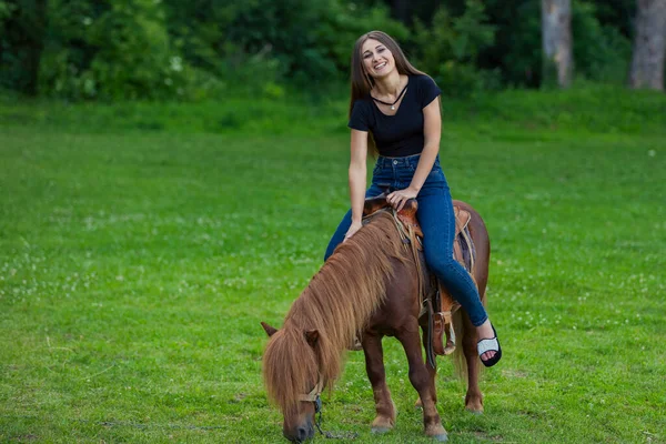 Chica montando un pony —  Fotos de Stock