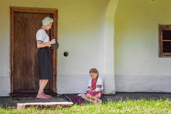 Мати і дочка стоять біля дверей від будинку — стокове фото