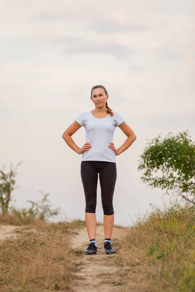 Donna che corre su una strada sterrata — Foto Stock