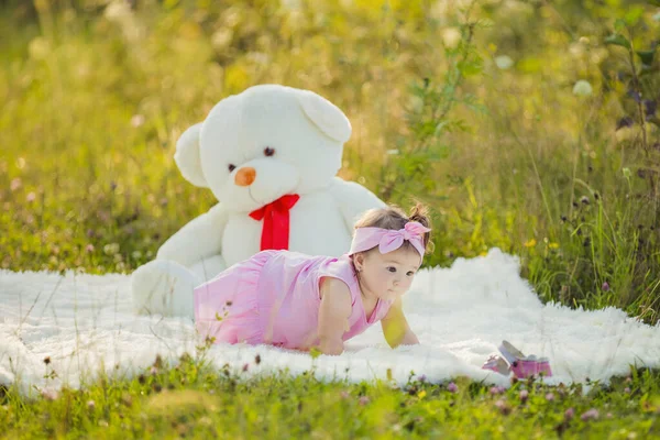Kind zit naast een grote teddybeer — Stockfoto