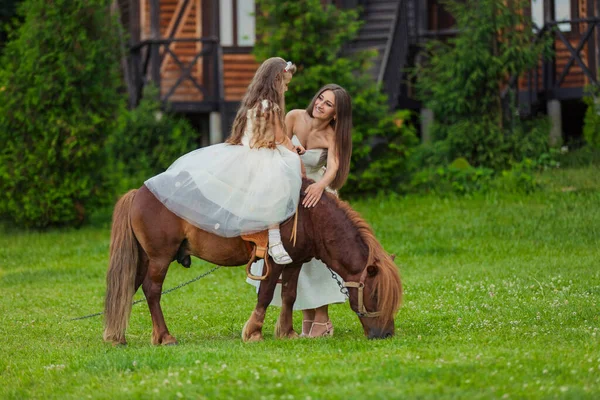 Madre monta a su hija en un pony —  Fotos de Stock