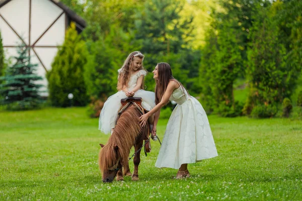 Mor rider sin dotter på en ponny — Stockfoto