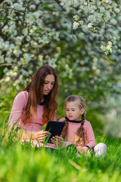 Mamma och dotter tittar på en tablett — Stockfoto