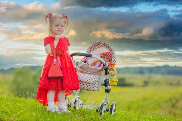 Девушка с игрушечной коляской — стоковое фото