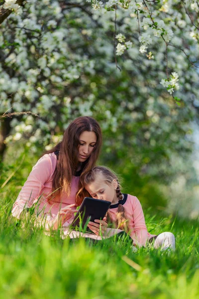 Mamá y su hija mirando una tableta —  Fotos de Stock