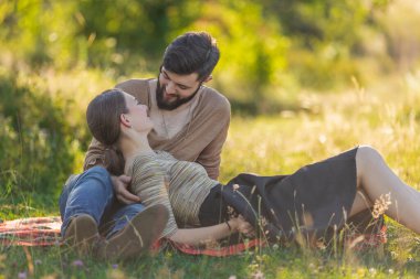 Genç çift doğada oturuyor.