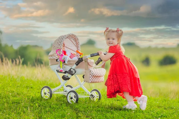 Oyuncak bebek arabası olan kız. — Stok fotoğraf
