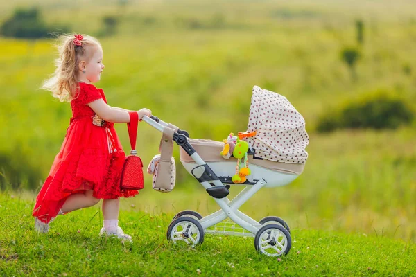 Oyuncak bebek arabası olan kız. — Stok fotoğraf