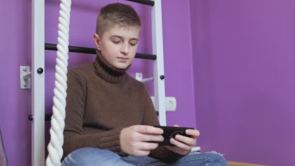 Хлопчик грає по телефону — стокове відео