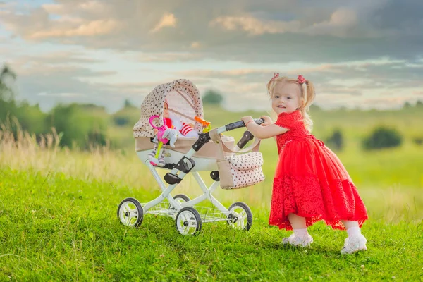 Girl with a toy stroller — Stock Photo, Image