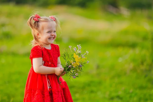 Meisje in rode jurk en bloemen — Stockfoto