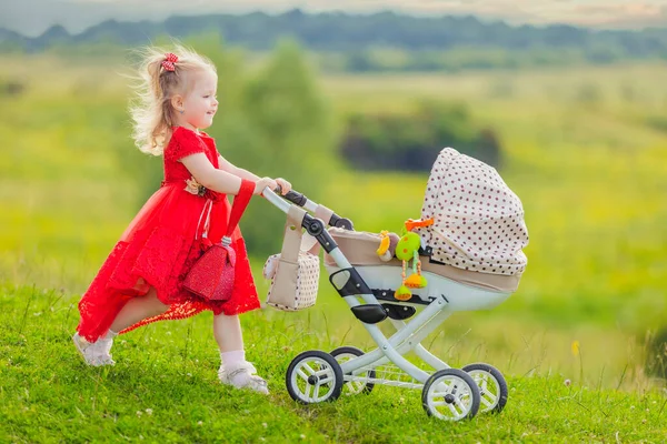 Girl with a toy stroller — Stock Photo, Image