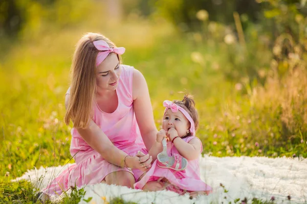 Anne ve kızı aynı pembe elbiseyi giymişler.