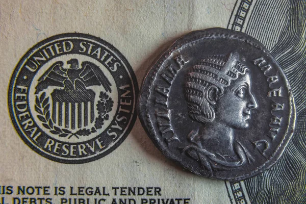100 달러짜리 지폐 위에 로마의 오래 된 동전이 놓여 있다 — 스톡 사진