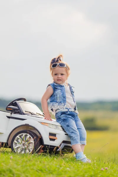 Menina em óculos de sol fica perto do carro — Fotografia de Stock