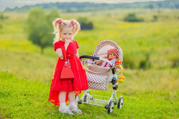 Meisje met een speelgoed wandelwagen — Stockfoto