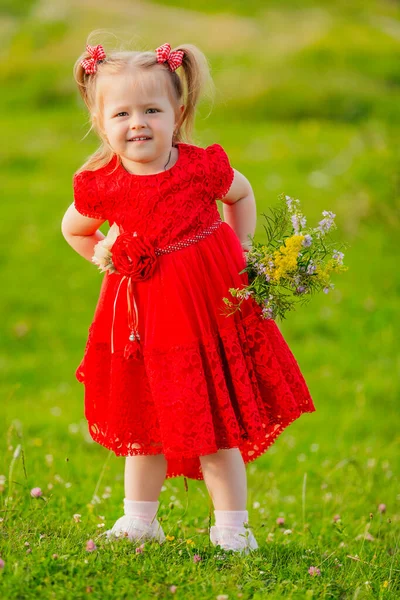 Flicka i röd klänning och blommor — Stockfoto