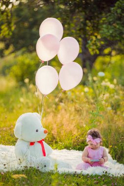 Battaniyenin üzerinde oturan telefonu olan bir kız.