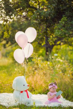 Battaniyenin üzerinde oturan telefonu olan bir kız.