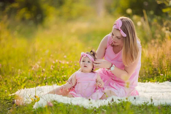 Anne ve kızı aynı pembe elbiseyi giymişler.