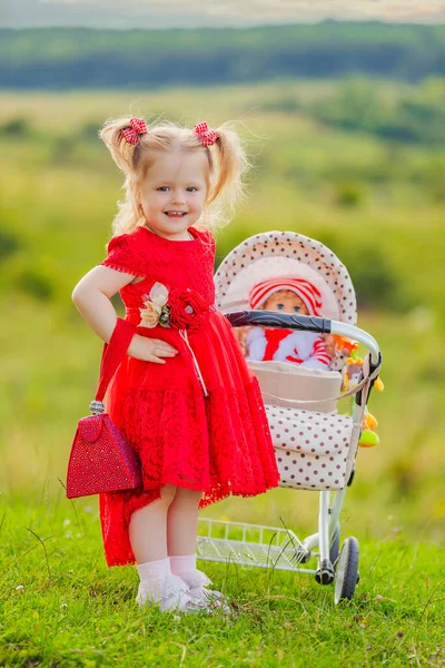 Meisje met een speelgoed wandelwagen — Stockfoto